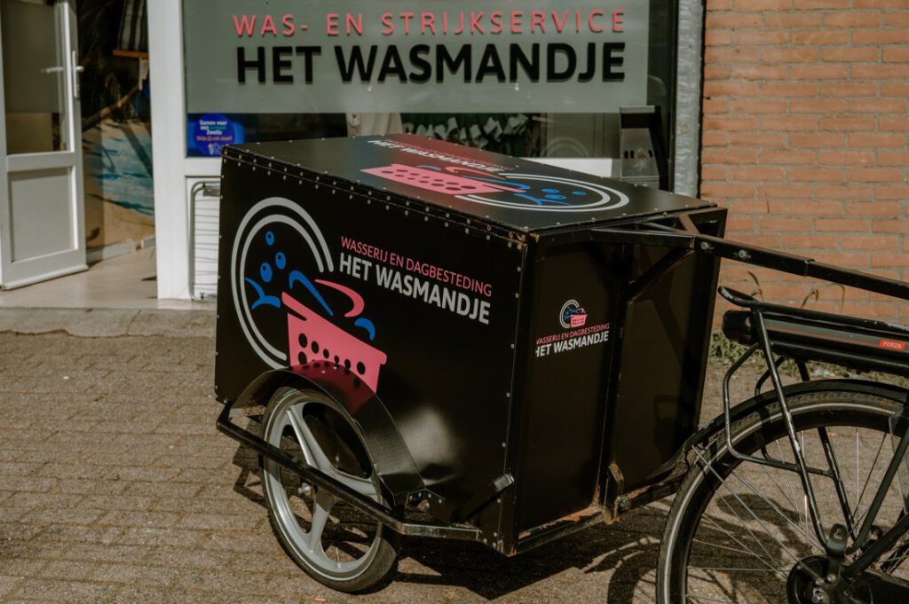 Bezorgfiets met wasbox van Het Wasmandje voor de winkel.